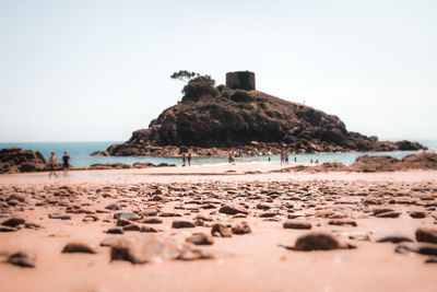 Rocks on beach against clear sky