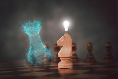 Close-up of illuminated chess pieces on table