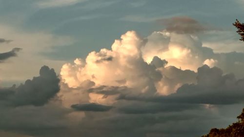 Low angle view of sunlight streaming through clouds