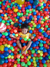 High angle view of boy in multi colored balls