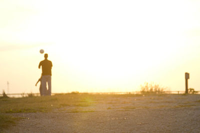 People walking on field against clear sky