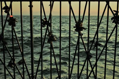 Silhouette people at sea shore against sky