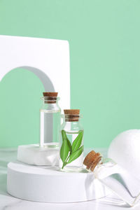 Little glass vial of aroma essential oil in arch. face serum in bottle on green table. spa relax