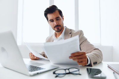 Portrait of businesswoman using laptop at office