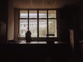 Businessman sitting on chair by window at office