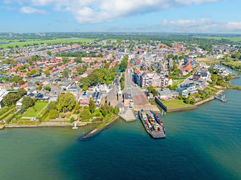 High angle view of city by sea against sky