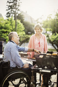 Happy mature couple barbecuing at yard