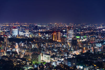 High angle view of illuminated buildings against sky at night