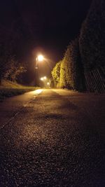 Road amidst trees against sky at night