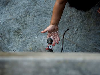 High angle view of child washing hand from faucet