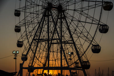 Low angle view of silhouette ferris wheel against sky at dusk