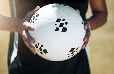 Midsection of man playing soccer at home