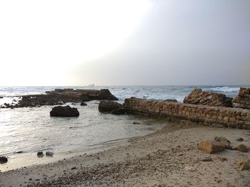 Rocks on beach against clear sky