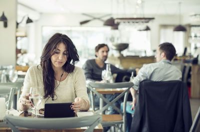 Businesswoman using digital tablet in restaurant