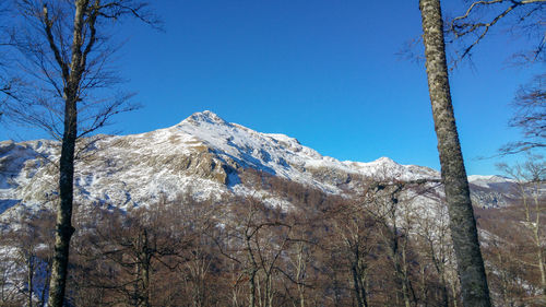 Scenic view of snowcapped mountains against clear blue sky