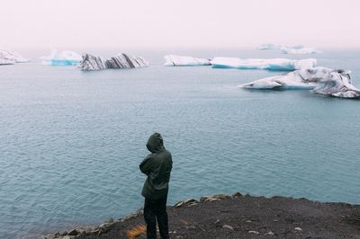 Rear view of man standing in sea