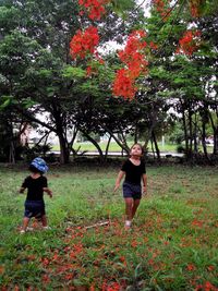 Full length of friends on tree in park