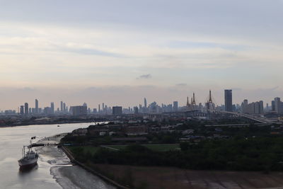 View of buildings in city against cloudy sky