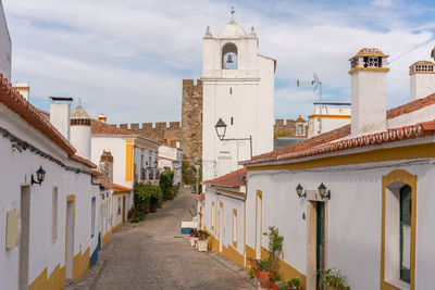 Alley amidst buildings in city against sky