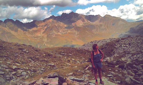 View of woman standing on mountain against sky