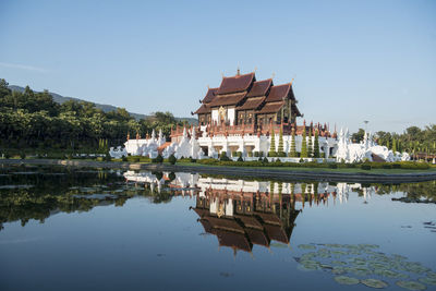 Reflection of building in lake against clear sky