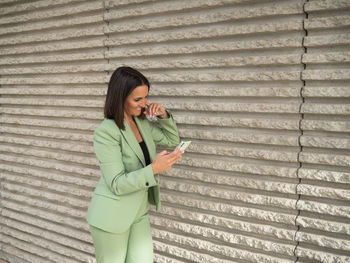 Side view of woman standing against wall