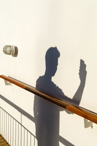 Reflection of man on railing against sky