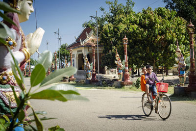 People riding bicycle on road in city