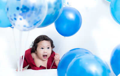 Portrait of a boy looking at blue balloons