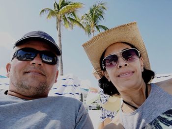 Portrait of young woman wearing sunglasses against sky