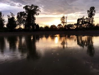 Scenic view of lake against sky at sunset