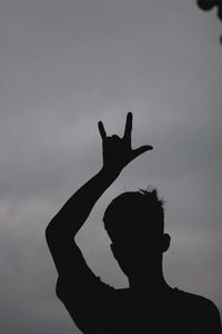 Silhouette man with arms raised