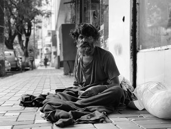 Portrait of beggar sitting on street