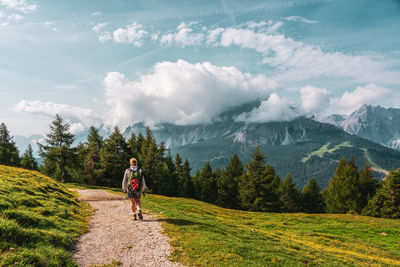 Backpacker on hiking trails in the dolomites, italy.