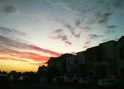 Buildings against cloudy sky at sunset
