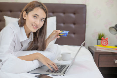 Young woman using mobile phone at home