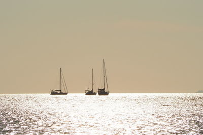 Ship sailing on sea against clear sky