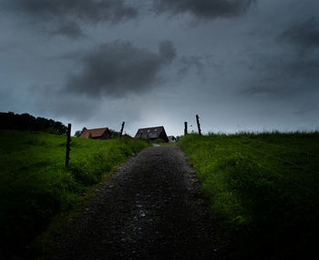 Scenic view of land and houses against sky