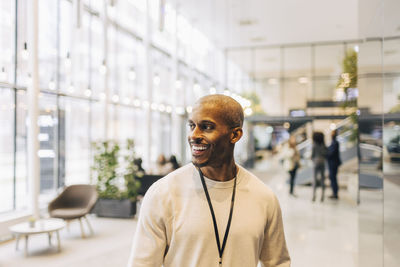 Happy male entrepreneur looking away while standing at convention center