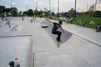 People skateboarding on street in city