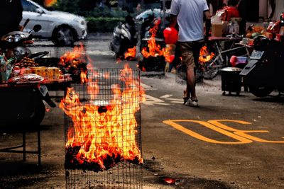 Fire pit on the road with man walking in background