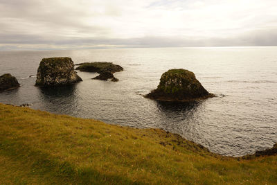 Rocks on sea shore against sky