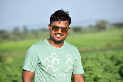 Mid adult man standing on field against sky