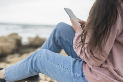 Midsection of woman using mobile phone