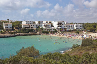 Scenic view of sea by buildings against sky