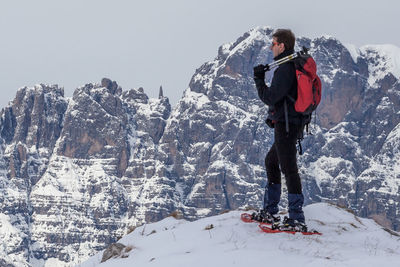 Full length of man standing on snowcapped mountain