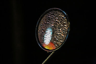 Close-up of wet side-view mirror at night