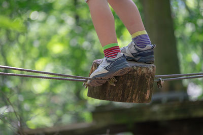 Low section of child hanging on rope