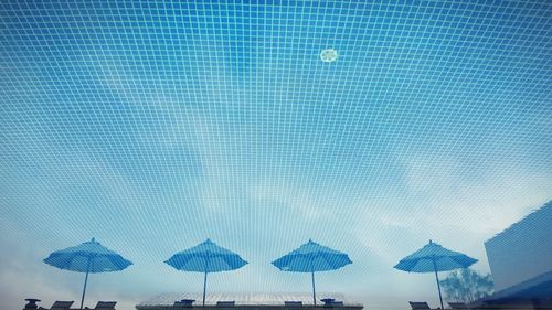 Upside down image of parasols reflection in swimming pool