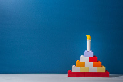 Stack of colored pencils on table against blue background
